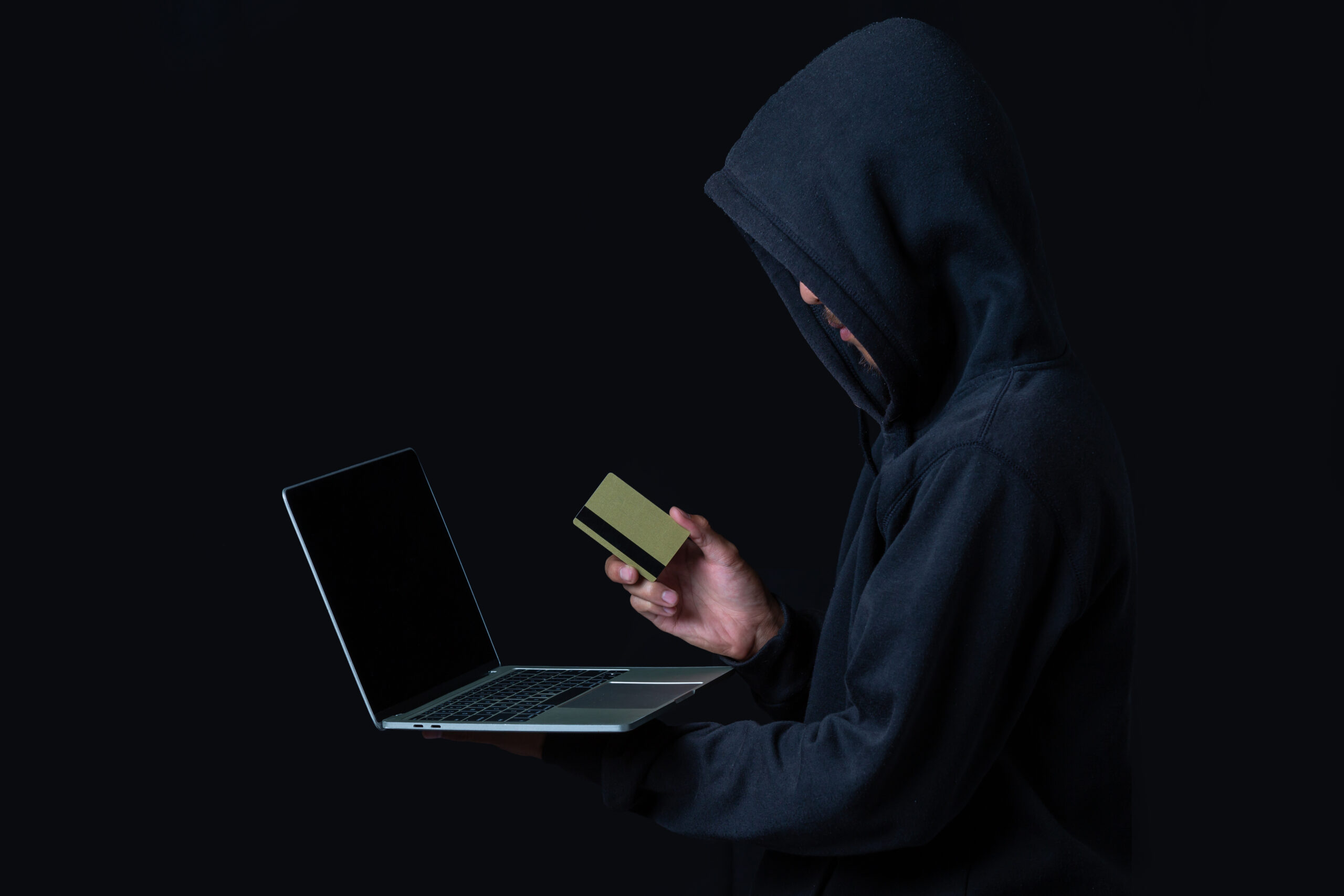 The concept of cyber theft. Hackers holding gold smart cards and
