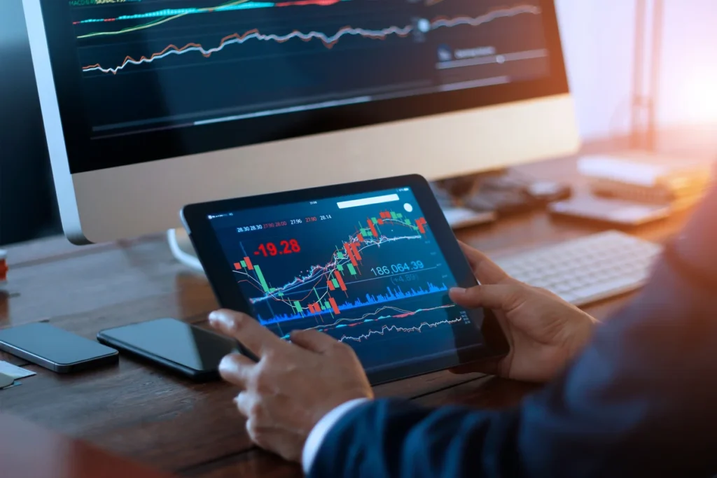 Businessman-trading-forex-using-tablet-and-computer